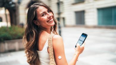 
		Young woman with a CGM sensor and a cell phone
	